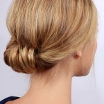 femeie blonda care si-a prins parul la spate in coc