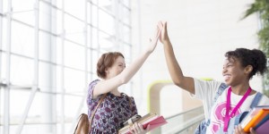 University students high fiving indoors